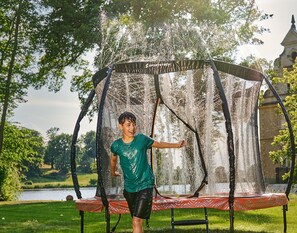 Un trampolín con sistema de aspersores que gira 360 grados en un parque.