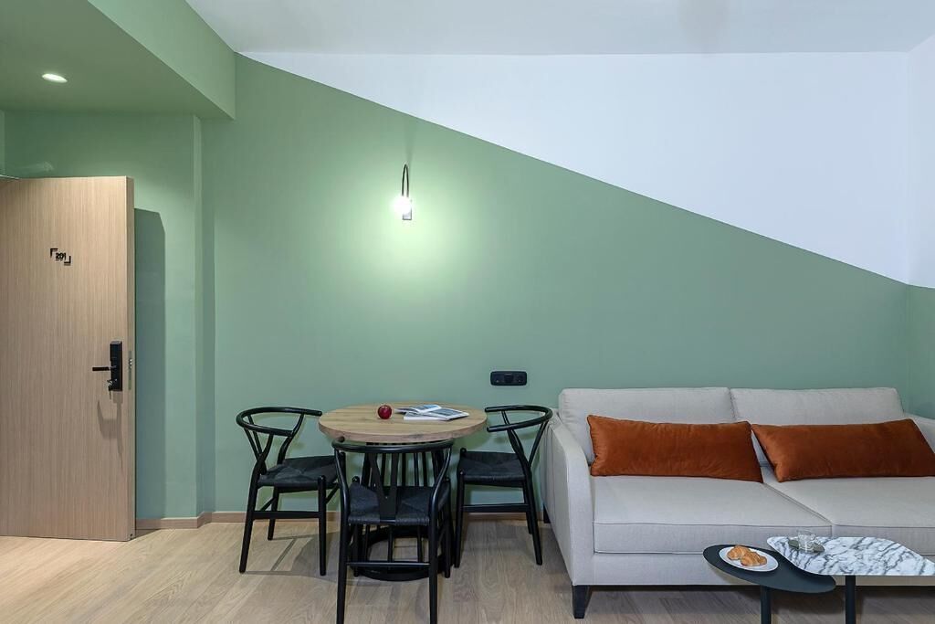 Uma sala de estar moderna com um sofá, uma mesa redonda e duas cadeiras.