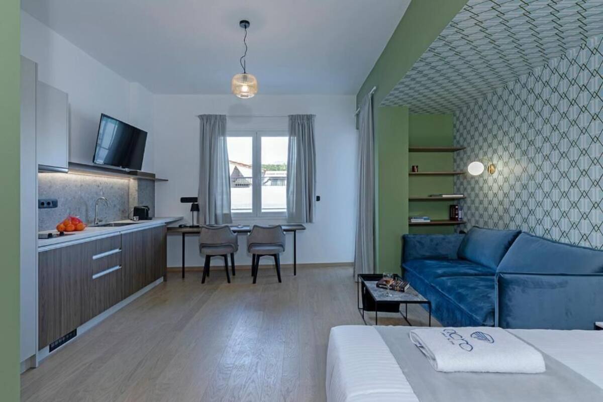 A compact living space with a kitchenette, a dining area, and a seating area with a sofa.