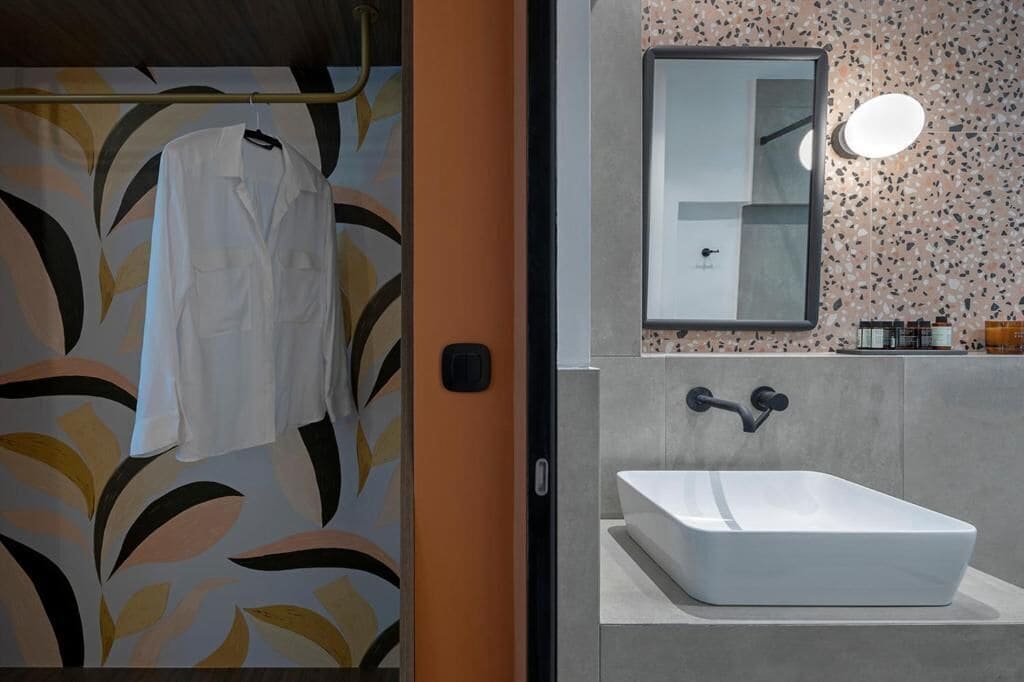 A bathroom with a white sink, a mirror, and a shower.