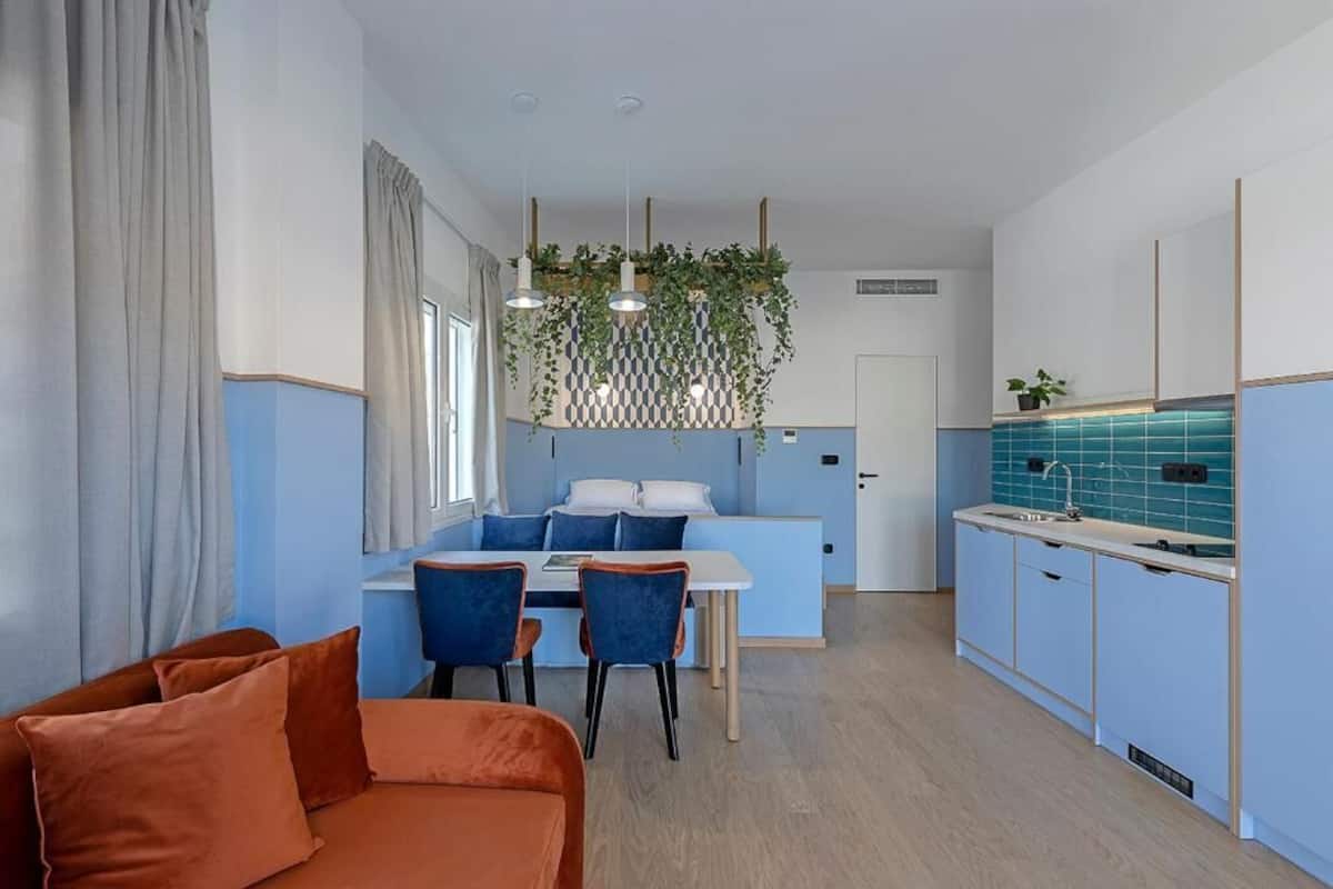 A compact living space with a dining area, kitchenette, and a sofa.