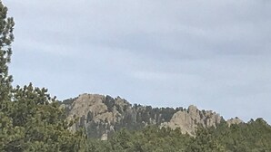 Ett bergigt landskap med tät skog vid foten av bergen.