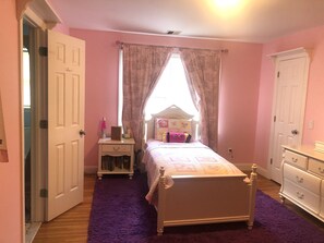 A bedroom with a bed, a nightstand, a dresser, and a window with curtains. - Country Living with Heated Pool and Hot Tub (Bedford)