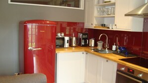 A compact kitchen with a red refrigerator, a microwave, a toaster, a sink, and a stove. - Cosy flat with a great view, near the centre of Hebden Bridge  (Hebden Bridge)