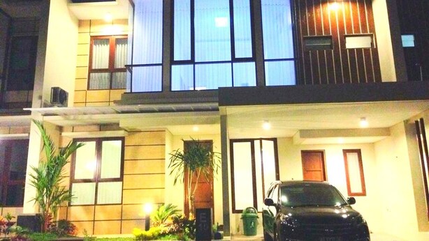 A modern two-story house with a car parked in the driveway. - Fams Homestay by FH Stay (Baturetno)