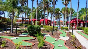 A miniature golf course with red-roofed structures, surrounded by palm trees and green pathways. - SO136CA - Amazing 4 Bedrooms Pool Home with Clubhouse Access (Davenport)