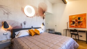 Un dormitorio con cama, lámparas de noche, escritorio y silla.