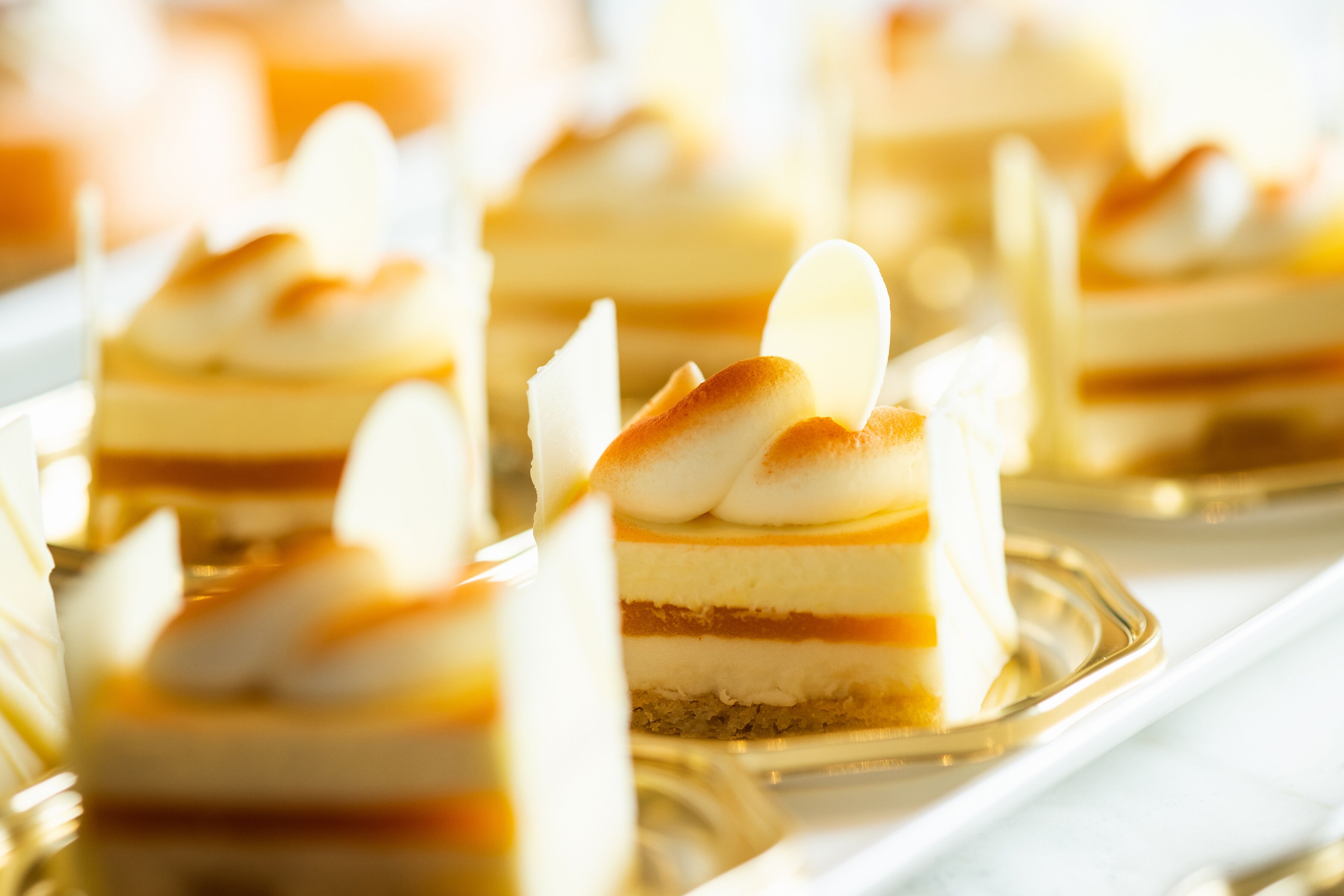 A dessert display with layered cakes and a golden tray.