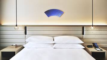 Et hotelværelse med en seng, to sengeborde, en vægmonteret lampe og et vægur.