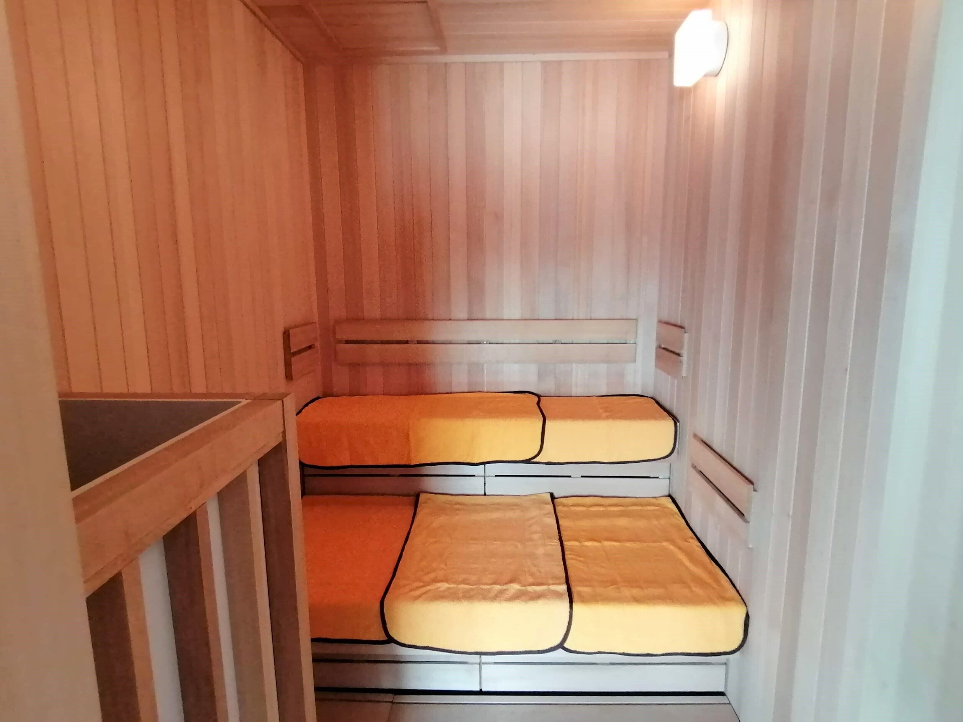 A small, wooden cabin-style room with a bunk bed and a single bed.