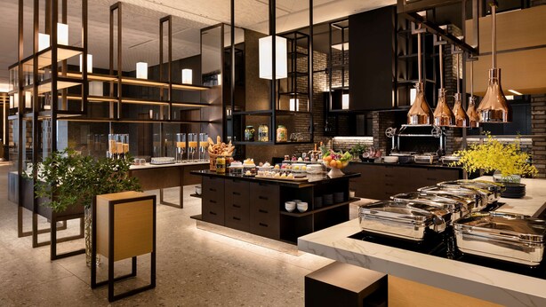 Una cocina moderna con una isla central, estantes empotrados y lámparas colgantes.