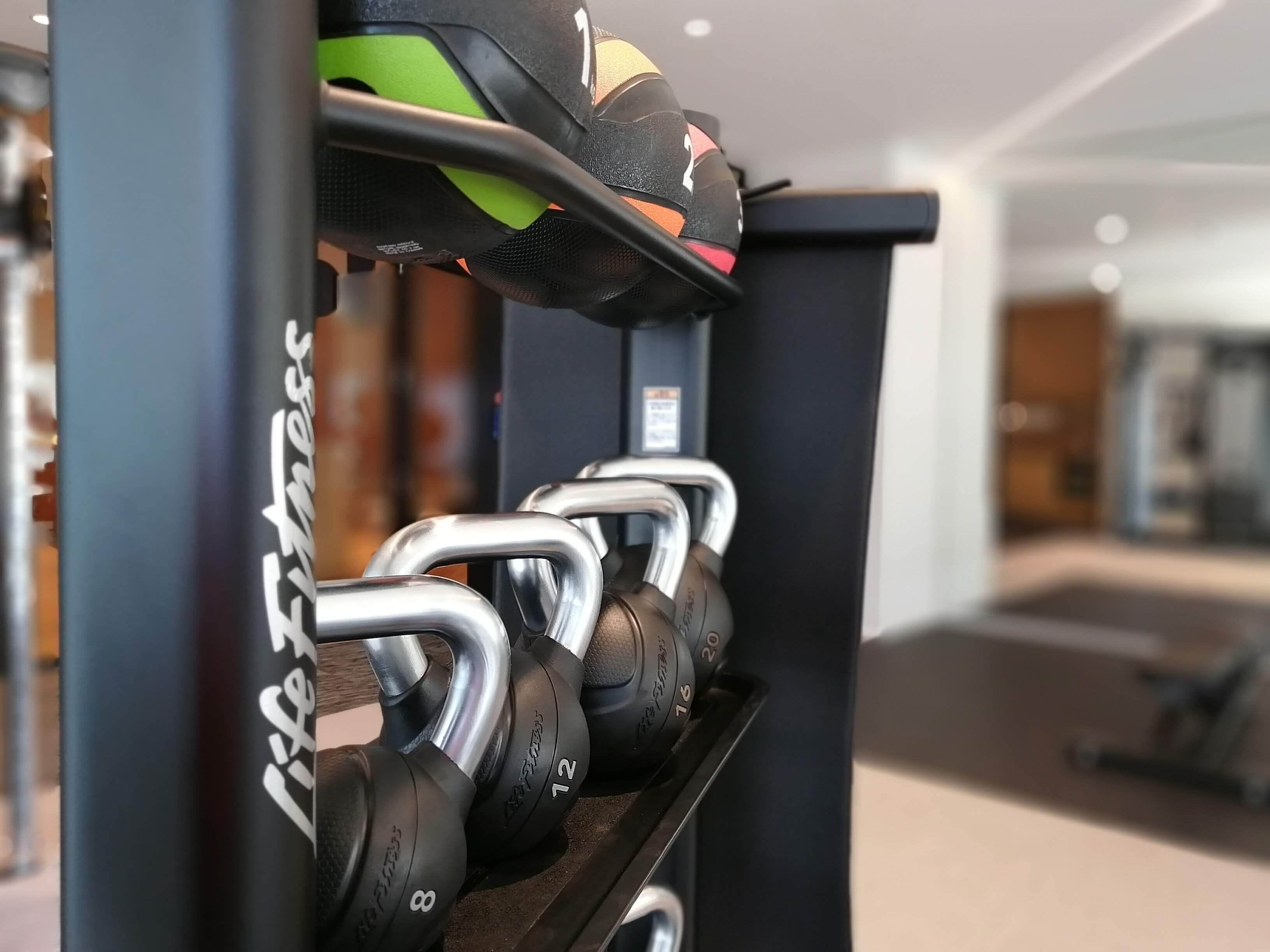 A rack of adjustable dumbbells with weight markings.