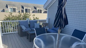 A deck with a round table and chairs, a sofa with cushions, and an umbrella. - Beautiful,  updated 3 bedroom home with parking for 6 cars in downtown Newport (Newport)