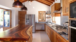 Eine moderne Küche mit Holzschränken, einem Edelstahlkühlschrank, einem Einbauofen und einem Gasherd.