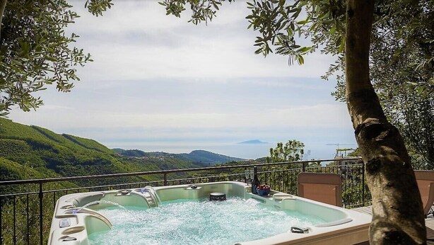 A hot tub on a balcony with a scenic view of hills and mountains. - Angolo di Paradiso (Vico Equense)