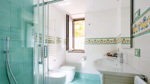 A bathroom with a glass shower enclosure, a toilet, and a sink. - Angolo di Paradiso (Vico Equense)
