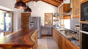 A modern kitchen with wooden cabinets, stainless steel appliances, and a large island.