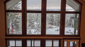 A large, multi-pane window with a view of snow-covered trees and a distant landscape. - Your Own Private Idaho for Summer Mountain Retreat (New Meadows)