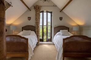 A bedroom with two wooden beds, a large window with curtains, and a view of greenery outside. - Five Acres, Boltby, North York Moors (Thirsk)