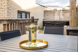 Une table avec une bouteille de vin blanc et un verre, le tout posé sur un plateau.