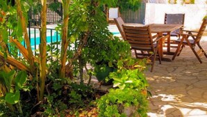 A patio with a stone floor, a wooden table and chairs, and a view of a swimming pool. - Kalliopi Private Pool Walk to Beach A C Wifi Car Not Required - 179 (Corfu)