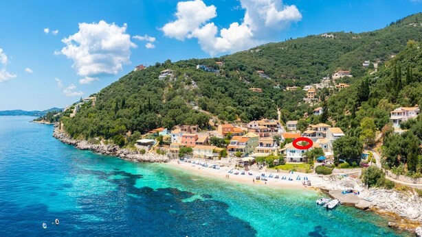 A coastal town with buildings on a hillside, a beach with sun loungers, and clear blue waters. - Kalliopi Private Pool Walk to Beach A C Wifi Car Not Required - 179 (Corfu)