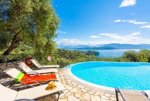 A poolside area with lounge chairs and a view of a lake and mountains. - Bougainvillea Large Private Pool Walk to Beach Sea Views A C Wifi Car Not Required Eco-friend - 195 (Corfu)