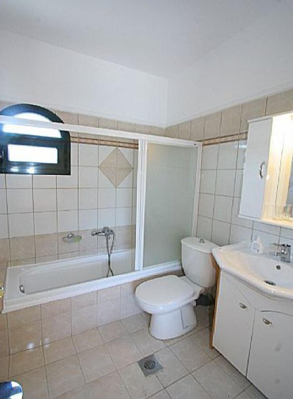 A bathroom with a bathtub, toilet, and sink.