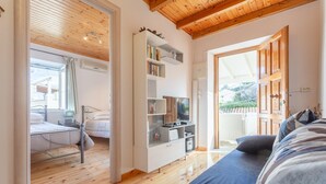 A modern room with a wooden ceiling, a bed, a TV, and a sofa. - Porto Walk to Beach Sea Views A C Wifi Car Not Required - 385 (Corfu)