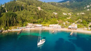 A coastal area with a marina, boats, and buildings on a hillside. - Porto Walk to Beach Sea Views A C Wifi Car Not Required - 385 (Corfu)