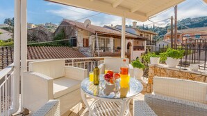 A balcony with wicker furniture, a glass table, and potted plants. - Porto Walk to Beach Sea Views A C Wifi Car Not Required - 385 (Corfu)