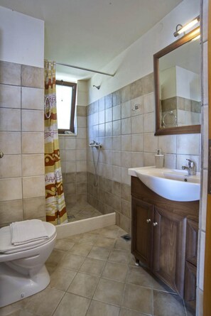 Ein Badezimmer mit Dusche, Toilette und Waschbecken.