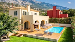 A villa with a swimming pool, outdoor seating, and a view of mountains. - Villa Katerina Large Private Pool Walk to Beach Sea Views A C Wifi Car Not Required - 1021 (Kefalonia)