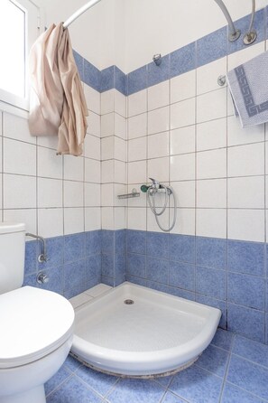 A bathroom with a shower, toilet, and sink.