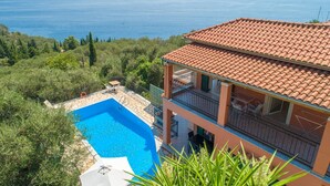 Un immeuble de deux étages doté d’une piscine, d’un balcon et offrant une vue sur la mer.