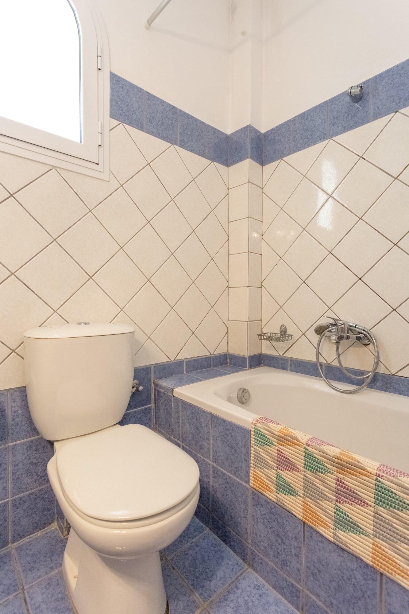A bathroom with a toilet, a bathtub, and a shower.