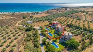 An aerial view of a coastal property with a pool, multiple buildings, and a view of the sea. - Andreas Beach Villa Large Private Pool Walk to Beach Sea Views A C Wifi Car Not Required - 1654 (Sfakia)