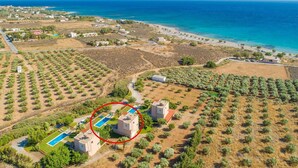 An aerial view of a coastal area with a beach, olive groves, and a swimming pool area with two buildings circled. - Andreas Beach Villa Large Private Pool Walk to Beach Sea Views A C Wifi Car Not Required - 1654 (Sfakia)