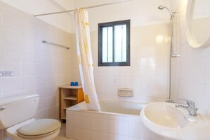 Un baño con inodoro, bañera y lavamanos.