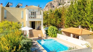 A two-story building with a swimming pool, outdoor seating, and a mountain backdrop. - Villa Ismini Large Private Pool A C Wifi Eco-friendly - 1877 (Kefalonia)