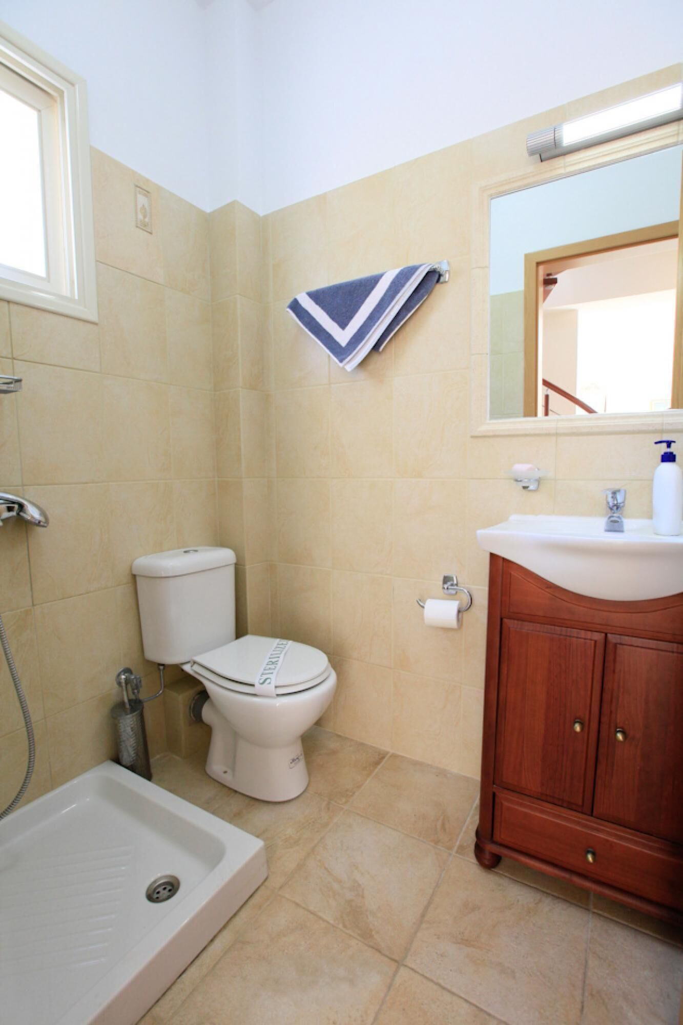 A bathroom with a toilet, sink, and shower.