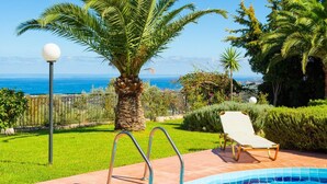 A swimming pool with a view of the sea, a palm tree, and a lounge chair. - Villa Sevos Large Private Pool Sea Views A C Wifi Car Not Required - 1891 (Rethymno)