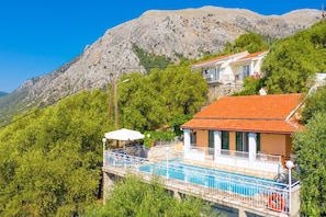 A coastal property with a swimming pool, a balcony, and a mountain backdrop. - Villa Elia Large Private Pool Walk to Beach Sea Views A C Wifi Car Not Required - 1978 (Corfu)