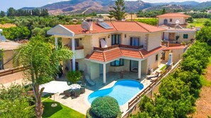 A large house with a swimming pool, surrounded by greenery and mountains in the background. - Villa Charianna Large Private Pool Walk to Beach Sea Views A C Wifi Car Not Required Eco-frie - 1985 (Ayia Marina Chrysochous)
