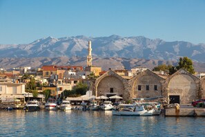 Stunning coastal town with a historic church and minaret, situated along a scenic waterfront with boats docked.