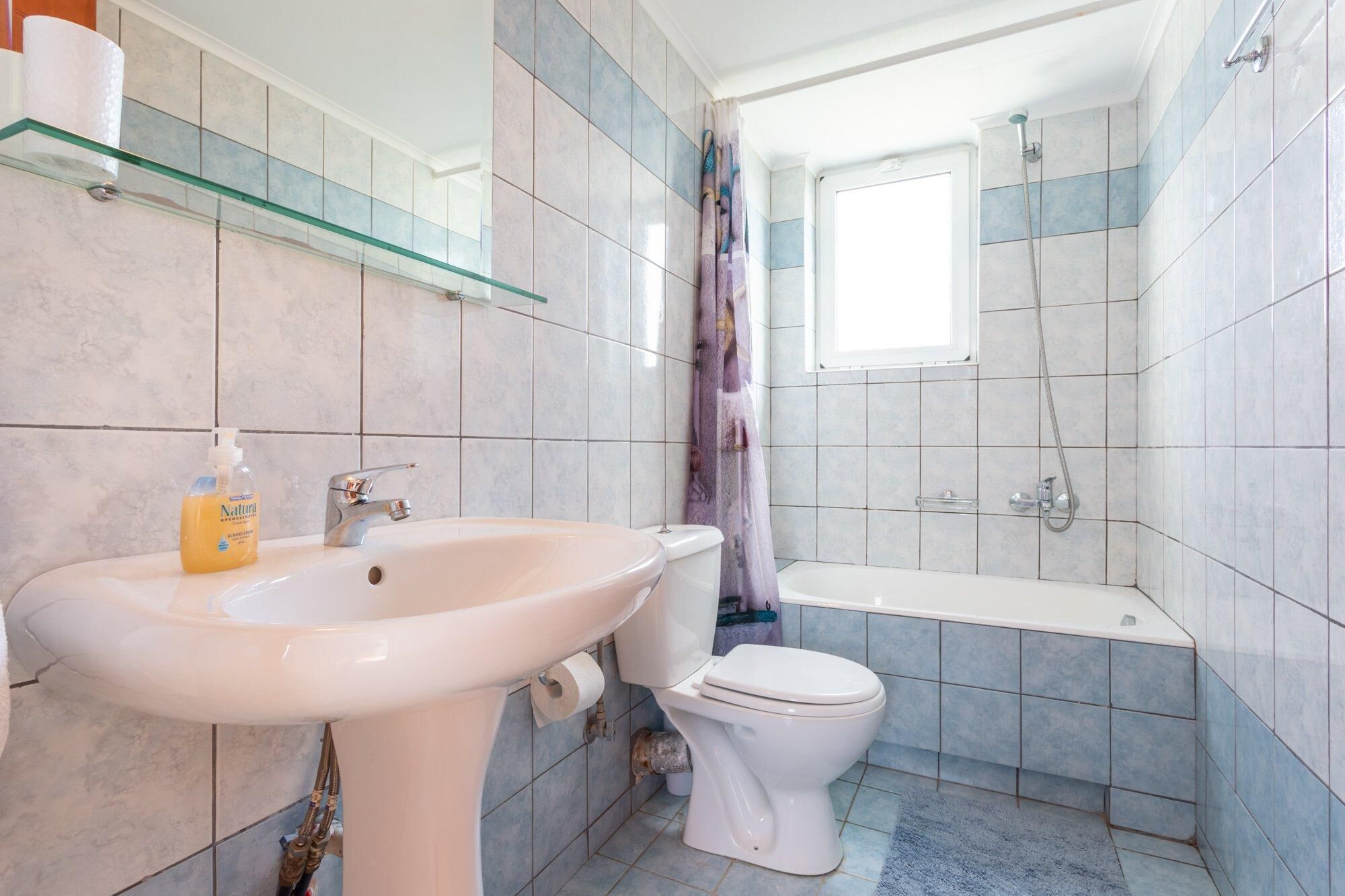 Un bagno con lavandino, water e vasca da bagno bianchi.