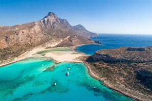 An aerial view of a coastal area with a prominent mountain, clear turquoise waters, and boats. - Ekklisies Tria Large Private Pool A C Wifi - 2090 (Apokoronas)