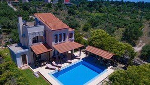 A modern two-story house with a swimming pool, outdoor seating, and a view of the surrounding landscape. - Ekklisies Tria Large Private Pool A C Wifi - 2090 (Apokoronas)