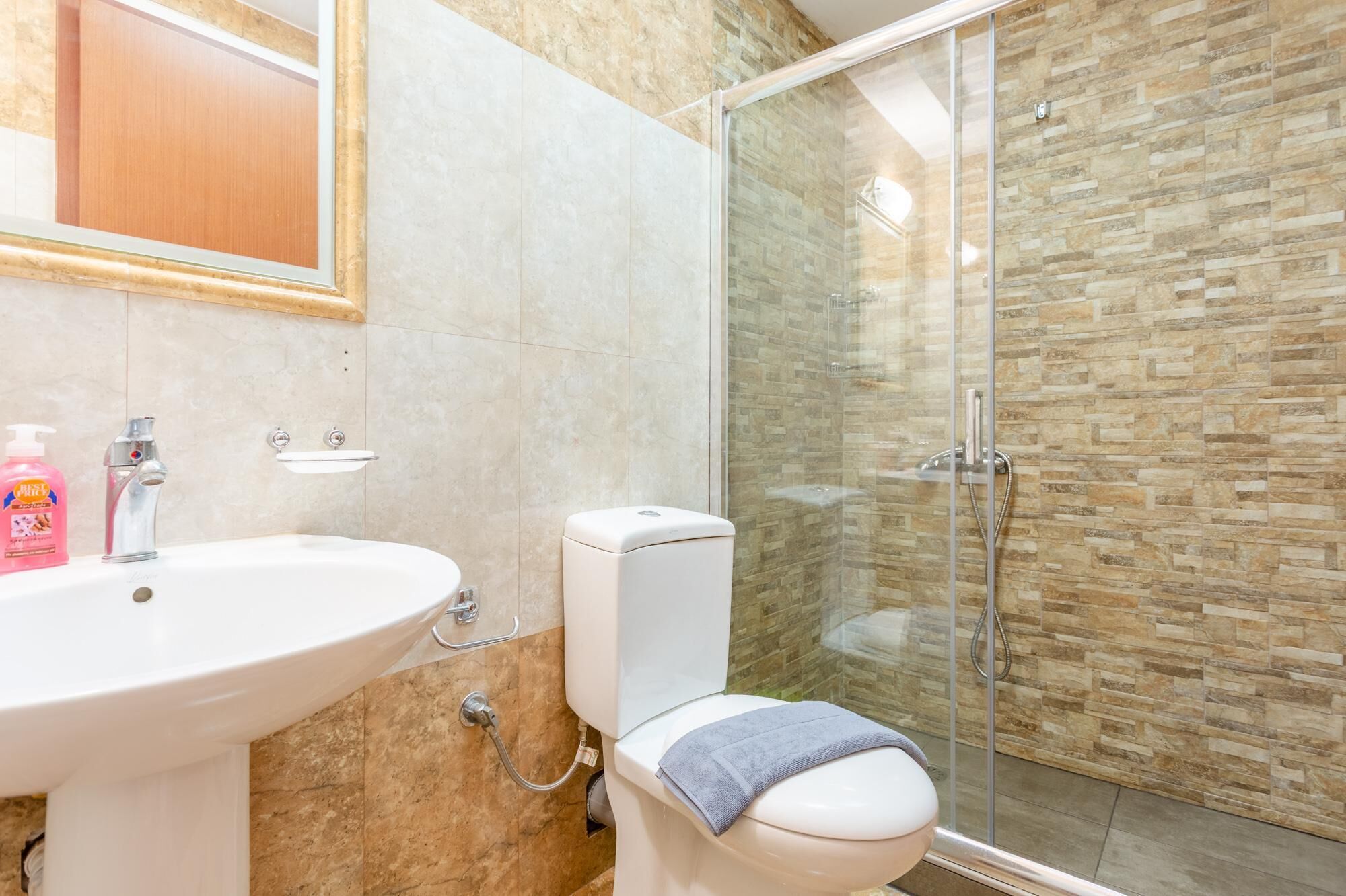 A bathroom with a sink, toilet, and glass shower enclosure.