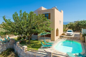 Uma villa moderna com piscina, área de estar ao ar livre e vista para a paisagem.